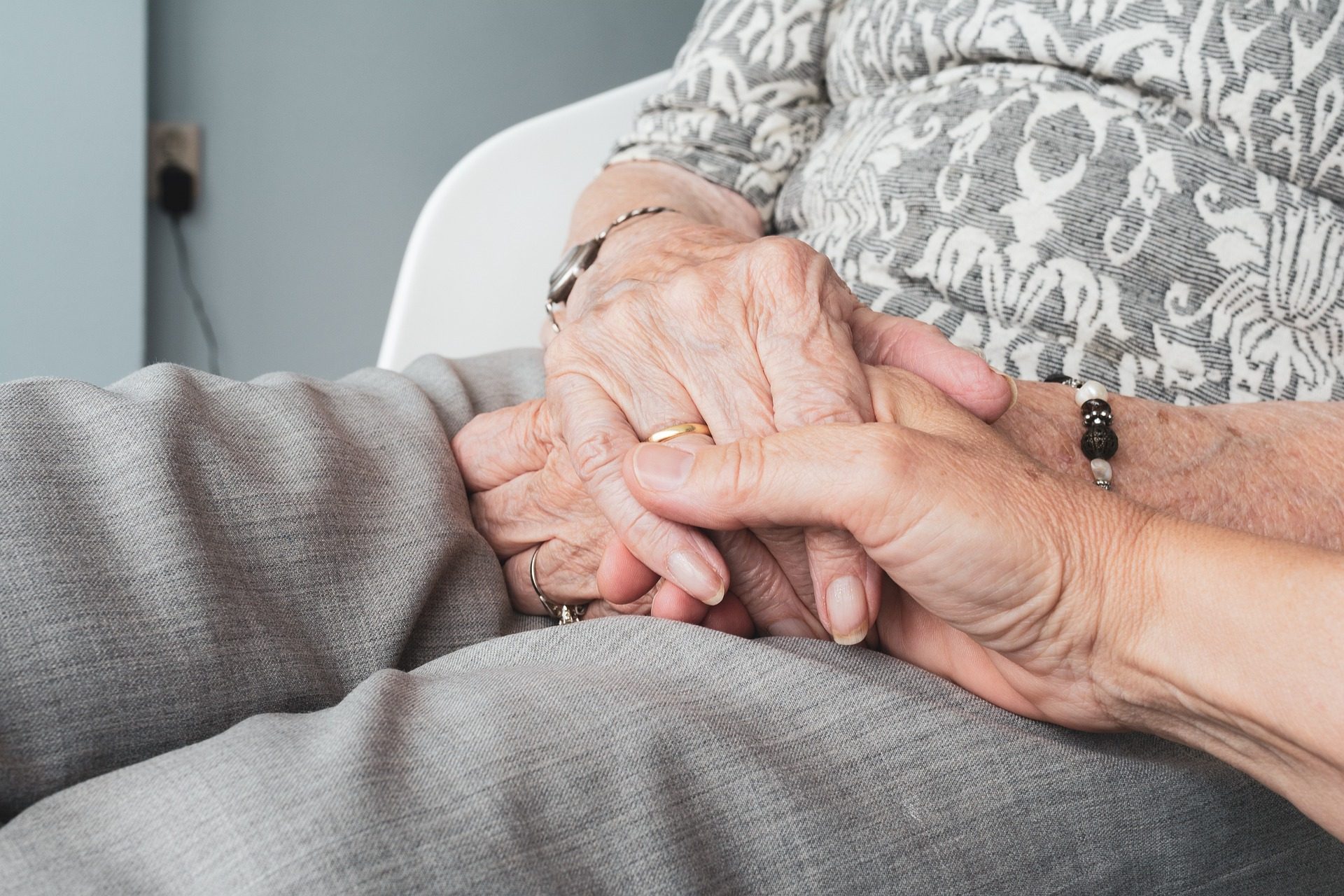 Two elderly people holding hands