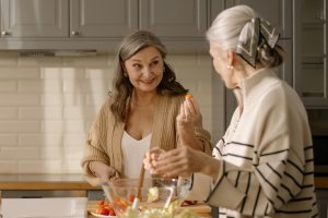 Two older women talking in the kitchen