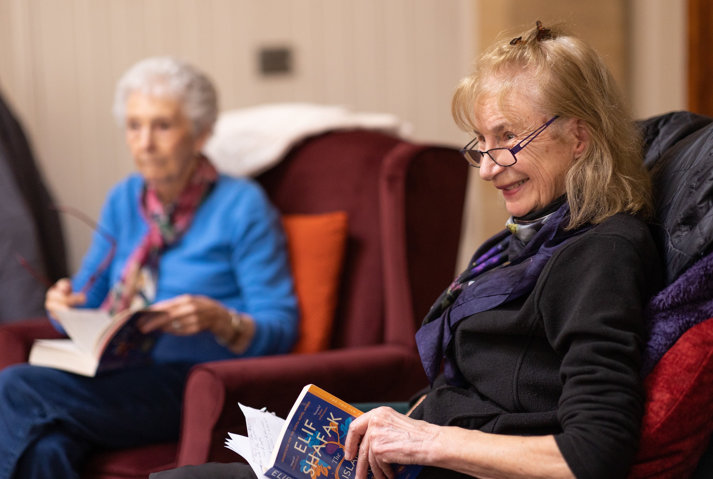 Two older women reading books