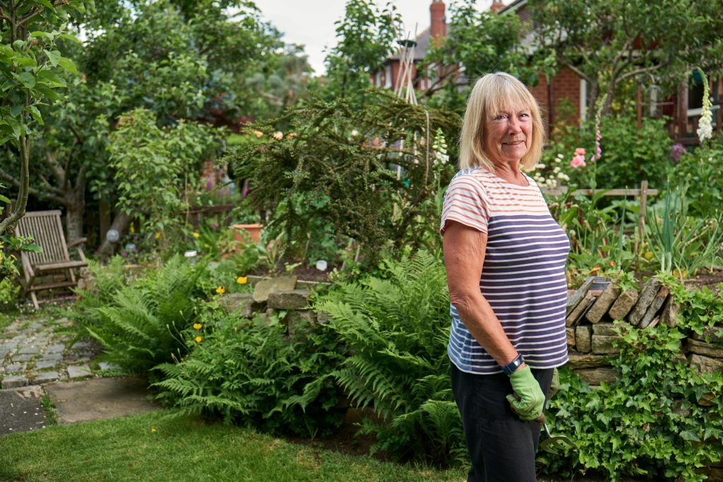 A woman posing for a photo in her garden